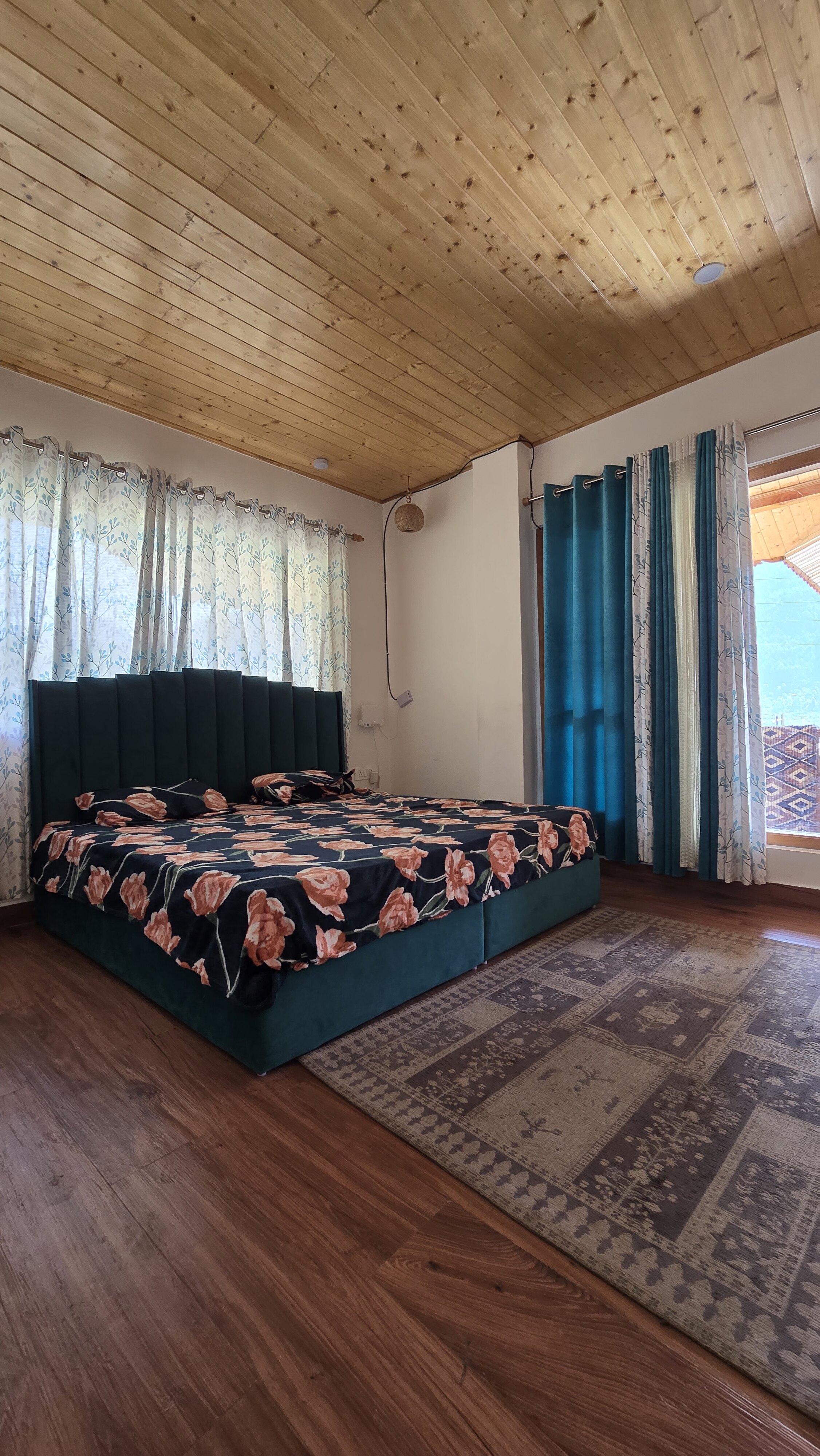 Spacious bedroom with wood ceiling at Forest Nook Manali
