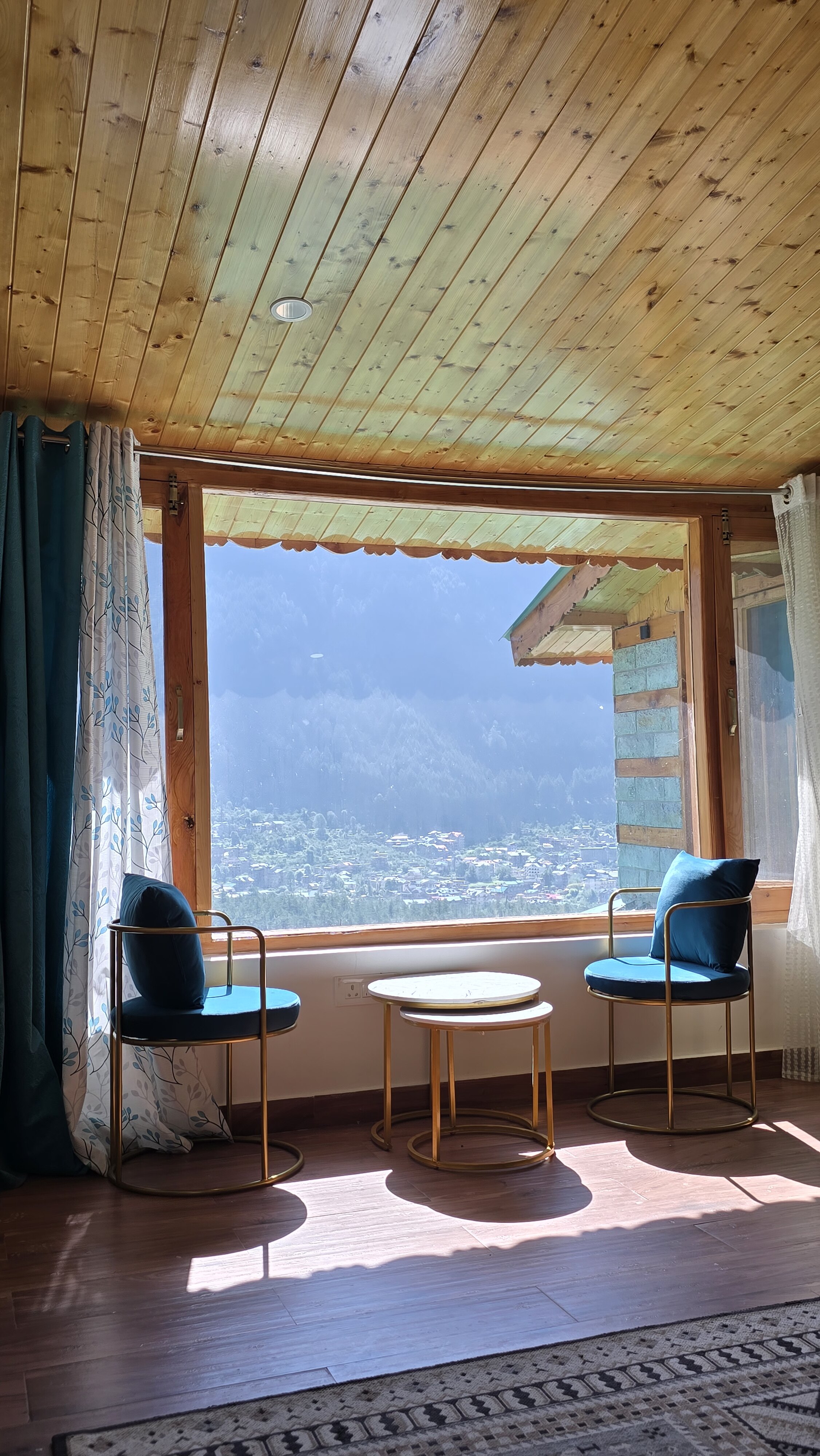 Mountain-view sitting area inside Forest Nook Manali